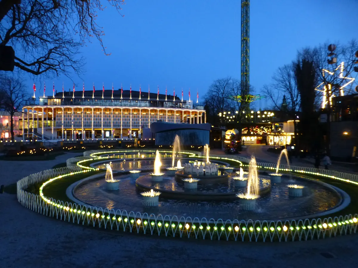 Opplyste fontener foran konsertsalen i Tivoli i København i blåtimen