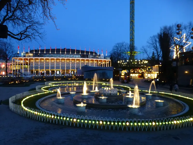 Opplyste fontener foran konsertsalen i Tivoli i København i blåtimen