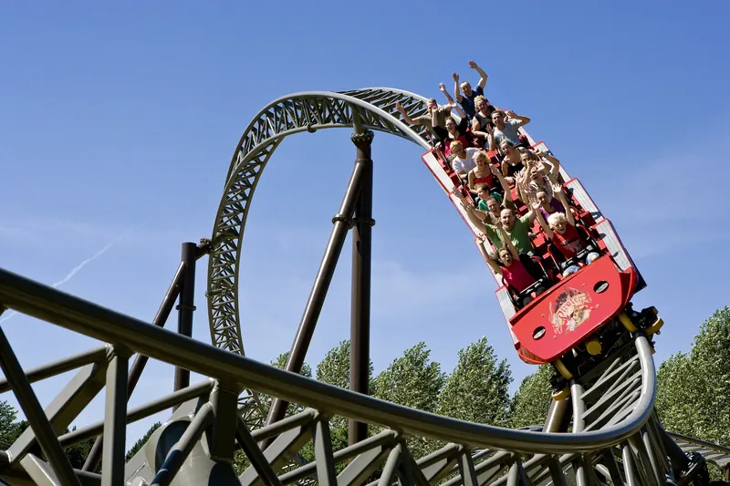 Berg-og-dal-bane med vogntog i en loop under blå himmel i Djurs Sommerland