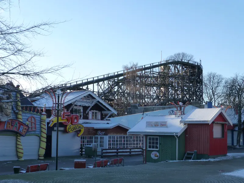 Den gamle trerutsjebanen og fargerike boder på Bakken en vinterdag med lett snø