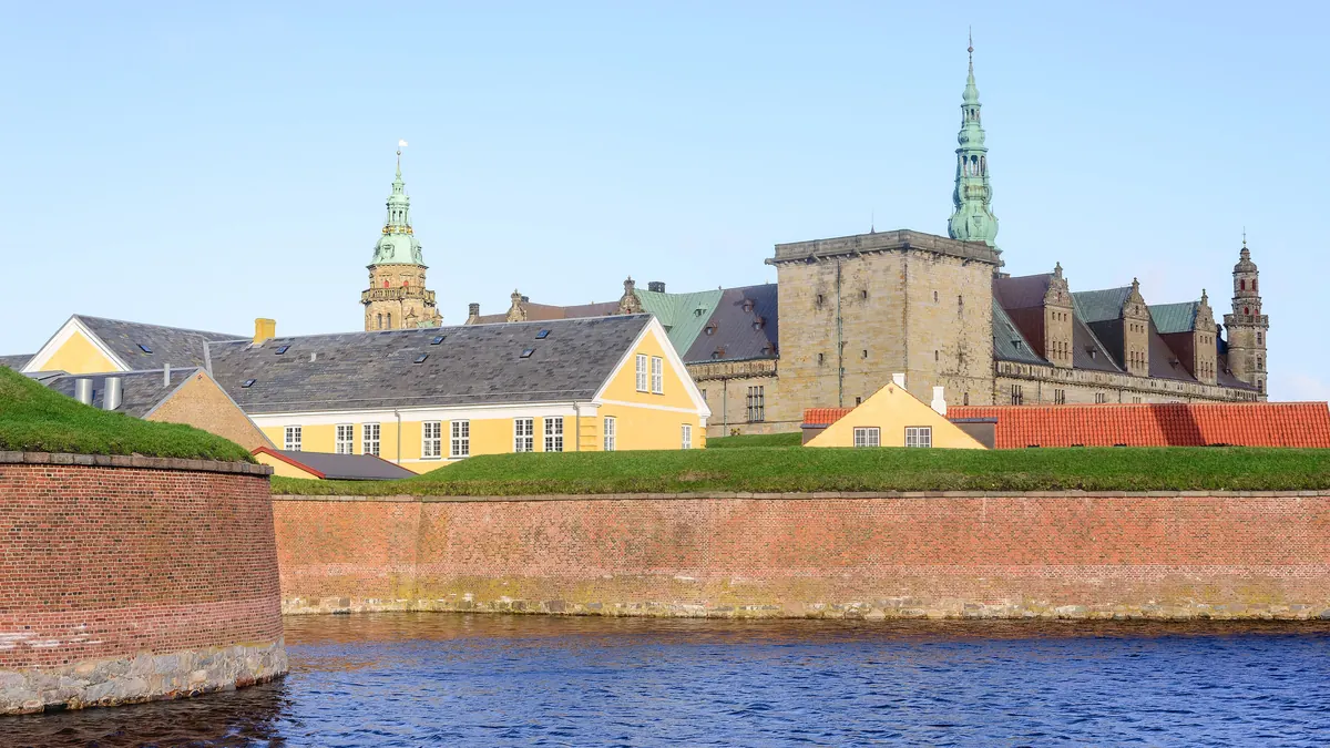 Kronborg slott med kobbertårn bak vollgraven og de røde festningsmurene