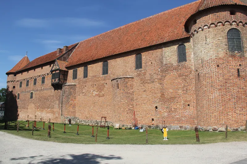 Den lange teglsteinsfløyen på Nyborg Slot med rundt hjørnetårn i sollys