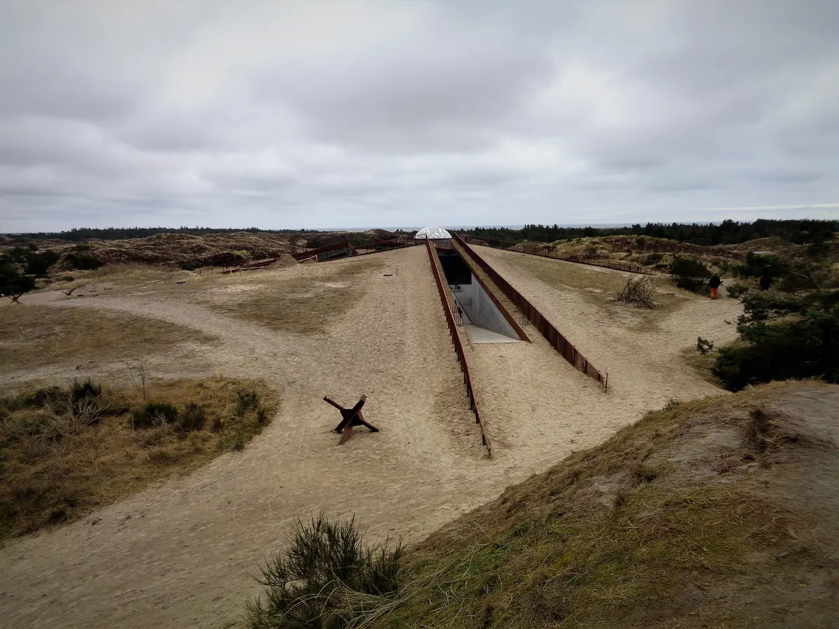 Tirpitz-museet i Blåvand, skåret ned i klitlandskapet med smale inngangskløfter