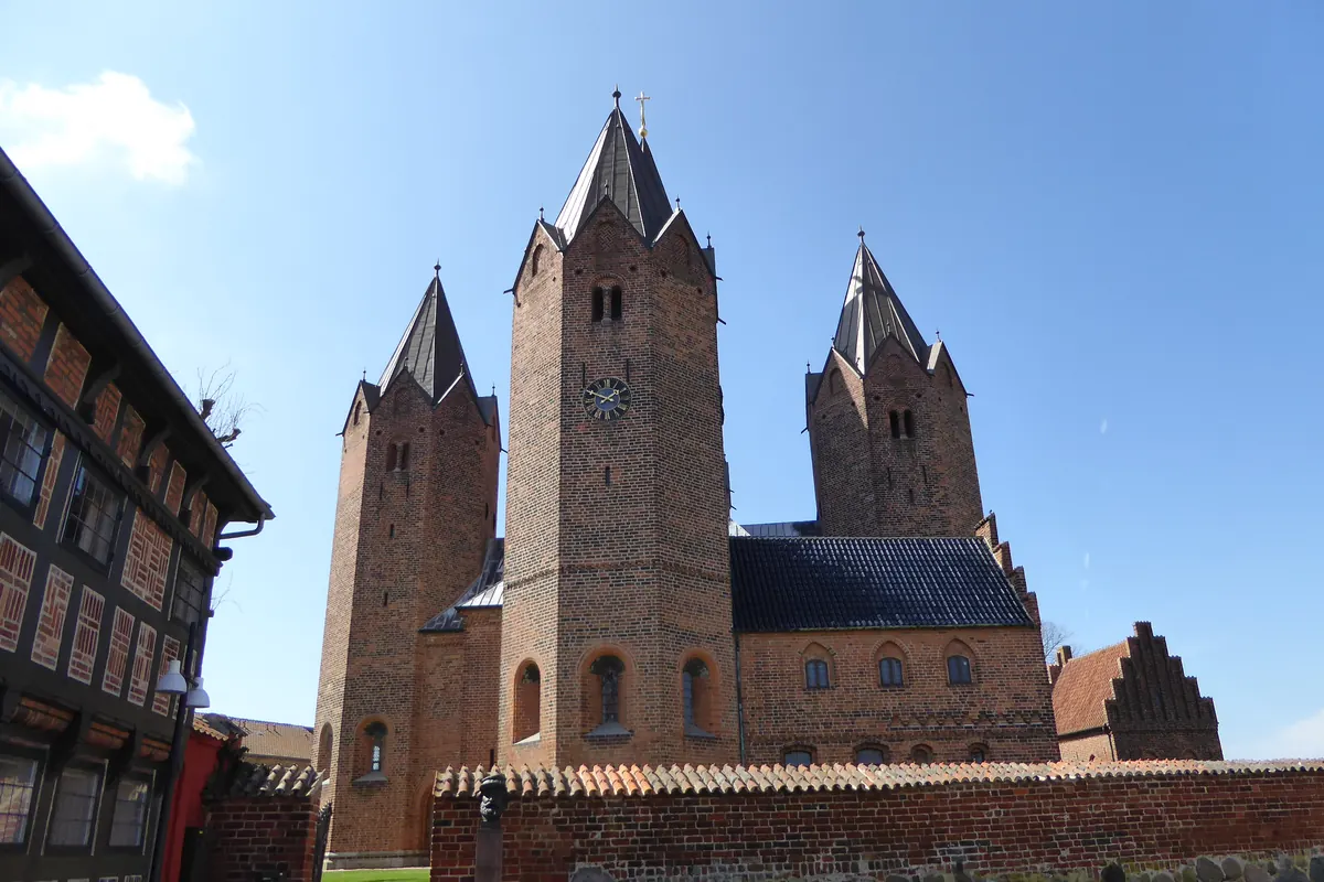 Vor Frue Kirke i Kalundborg med sine fem teglsteinstårn under blå himmel