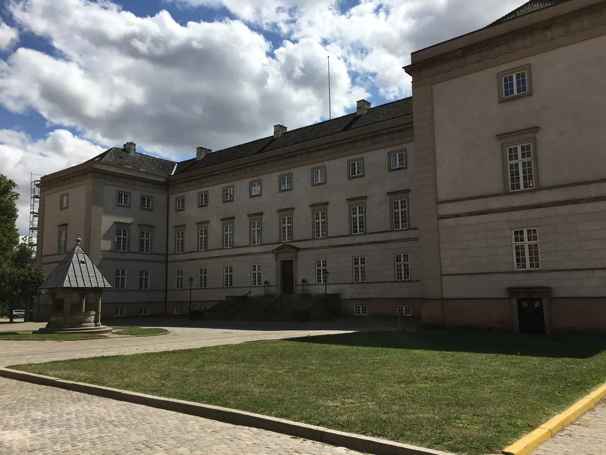 Hovedbygningen til Sorø Akademi med gressplen foran under skyet himmel