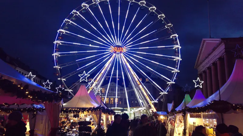 Julemarked med opplyst pariserhjul og boder en vinterkveld på Kongens Nytorv i København