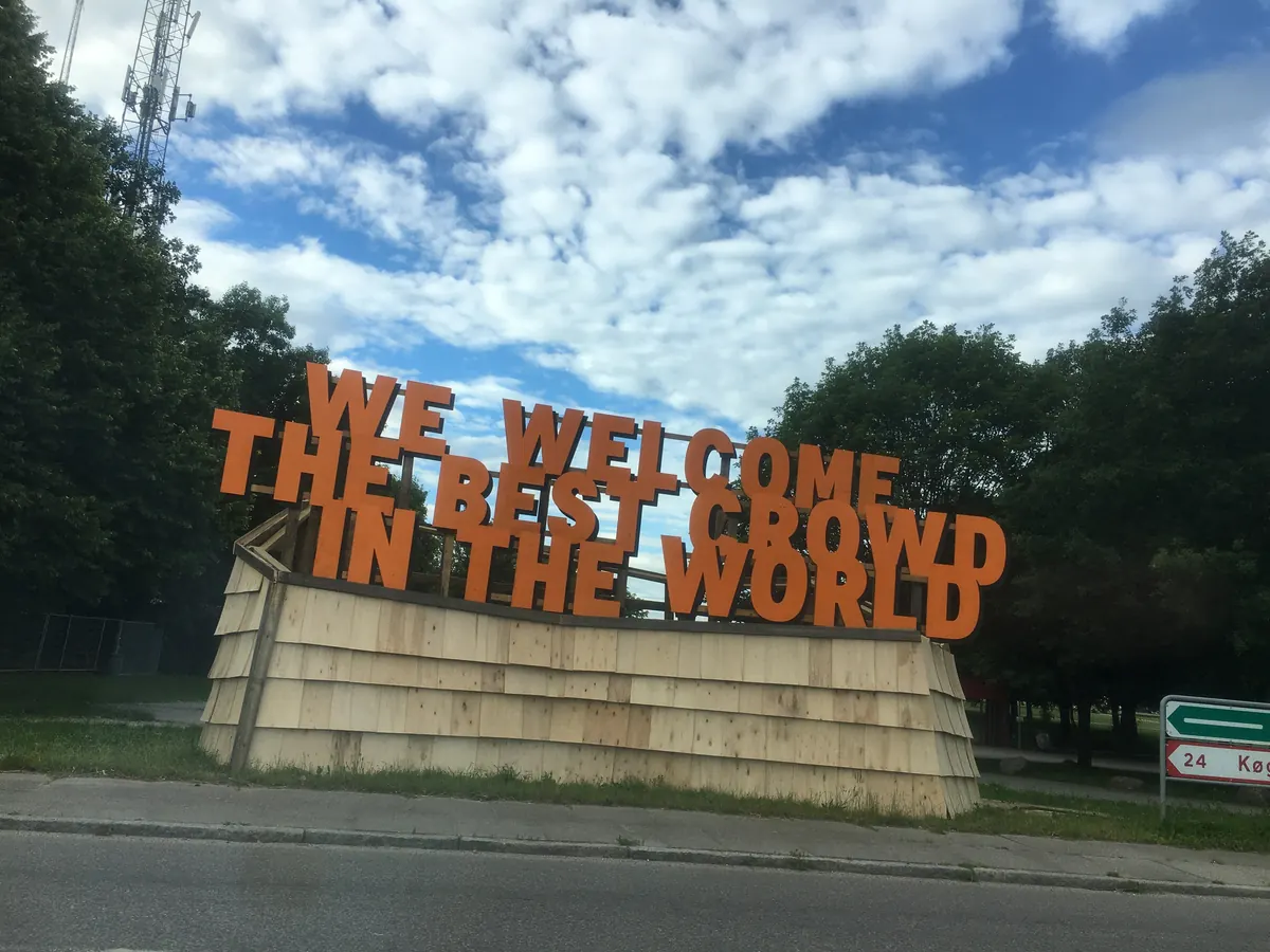 Oransje velkomstskilt til Roskilde Festival med teksten «We welcome the best crowd in the world»