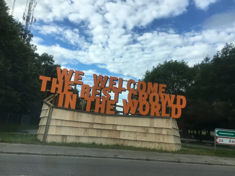Oransje velkomstskilt til Roskilde Festival med teksten «We welcome the best crowd in the world»