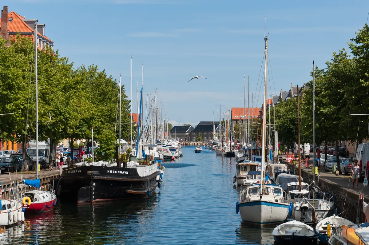 Seilbåter fortøyd langs Christianshavns Kanal i København en solrik dag
