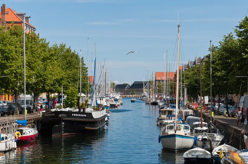 Seilbåter fortøyd langs Christianshavns Kanal i København en solrik dag