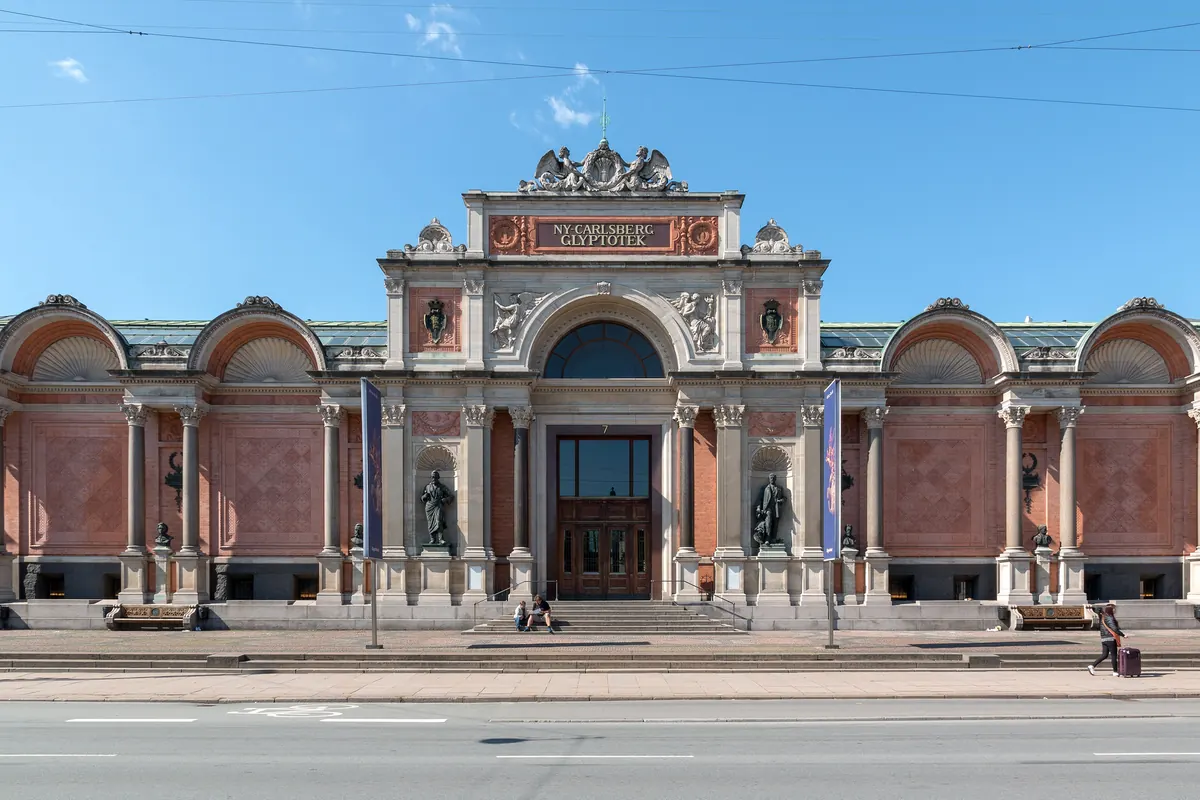 Fasaden på Ny Carlsberg Glyptotek i rød murstein og lys stein en solskinnsdag