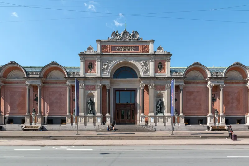 Fasaden på Ny Carlsberg Glyptotek i rød murstein og lys stein en solskinnsdag