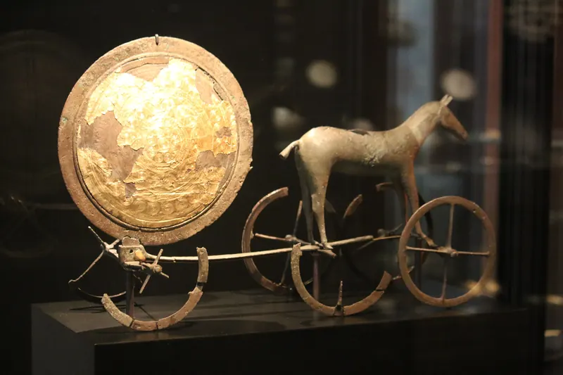 Solvognen fra bronsealderen, en hest som trekker en forgylt solskive, utstilt i en montre på Nationalmuseet