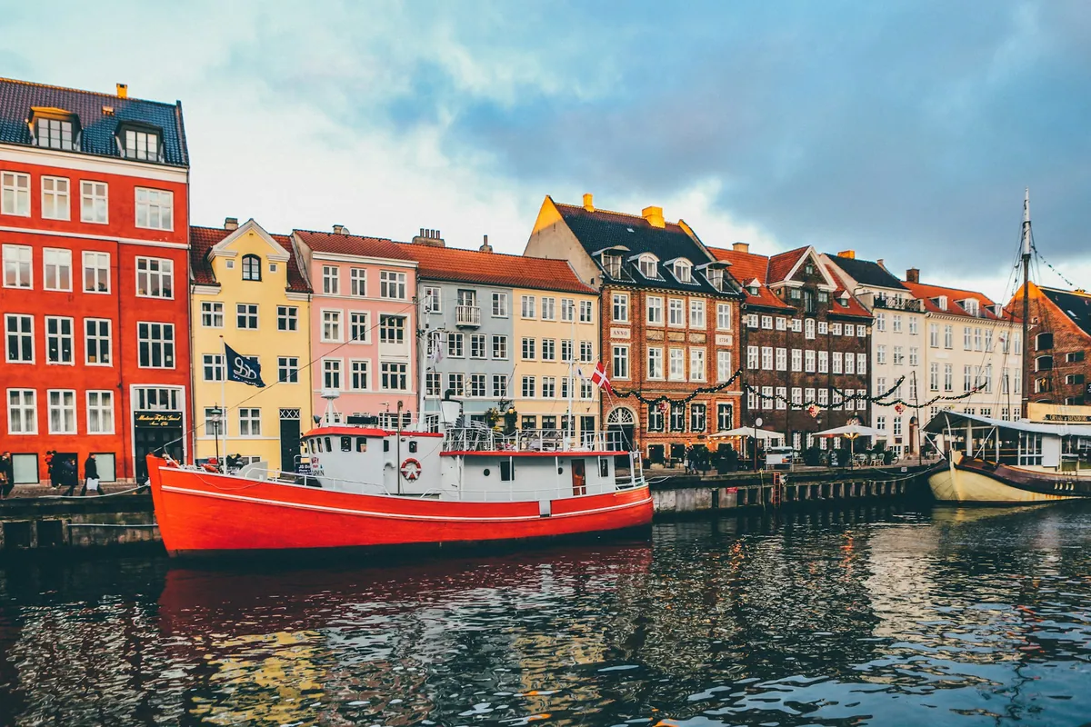 Fargerike hus og en rød båt i Nyhavn i København