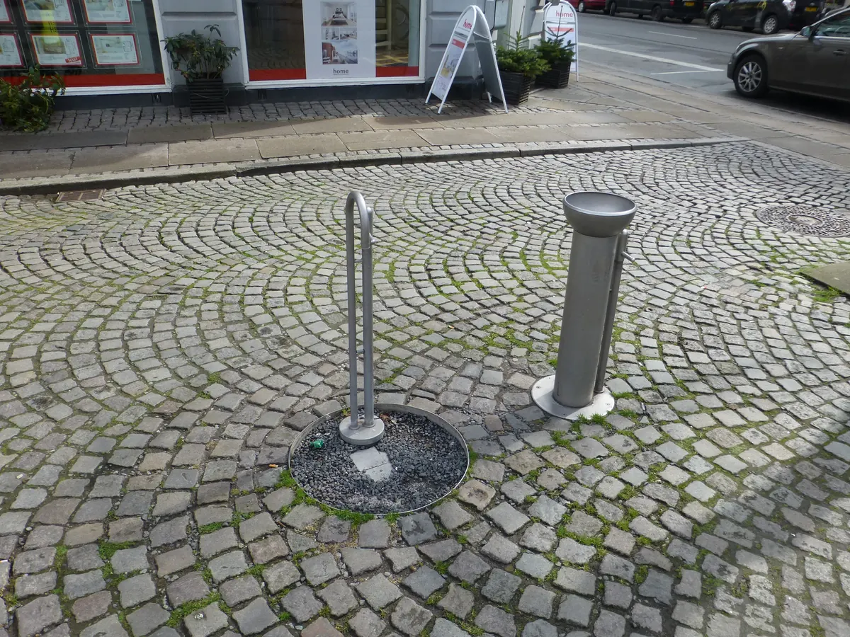 Offentlig drikkefontene av stål på en brosteinsbelagt plass i København