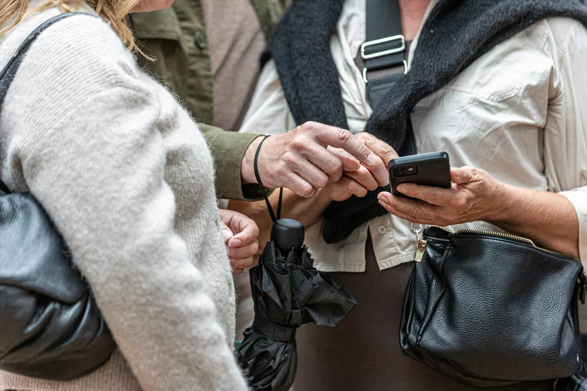 To personer ser sammen på skjermen til en mobiltelefon