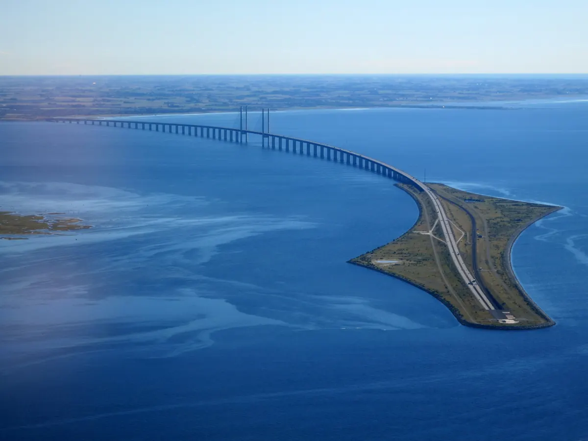 Øresundsbroen og den kunstige øya Peberholm sett fra luften over blått hav