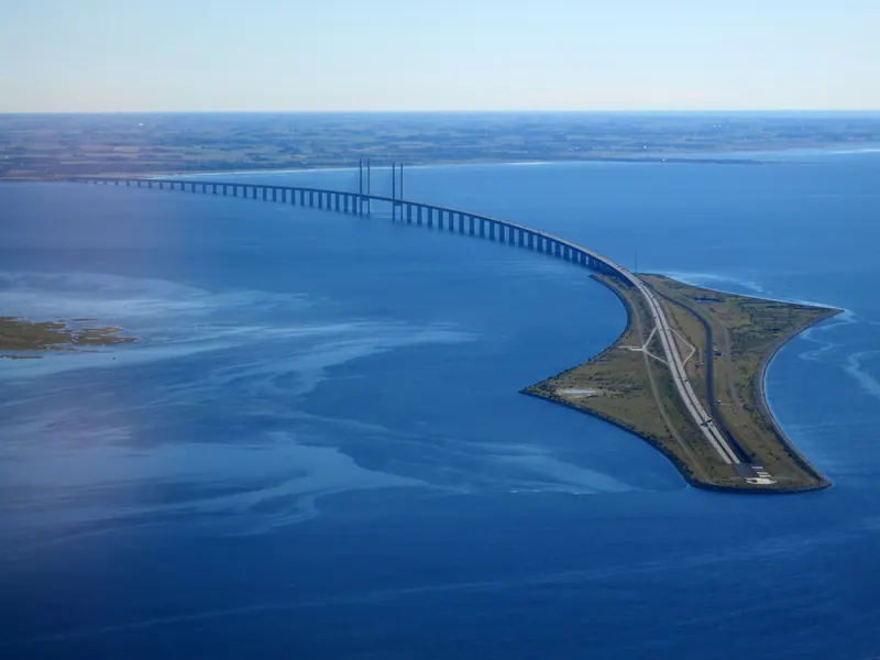 Øresundsbroen og den kunstige øya Peberholm sett fra luften over blått hav