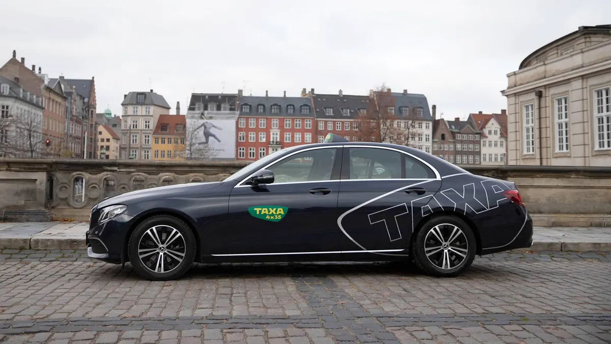 Mørk taxi med Taxa-logo parkert på Marmorbroen i København
