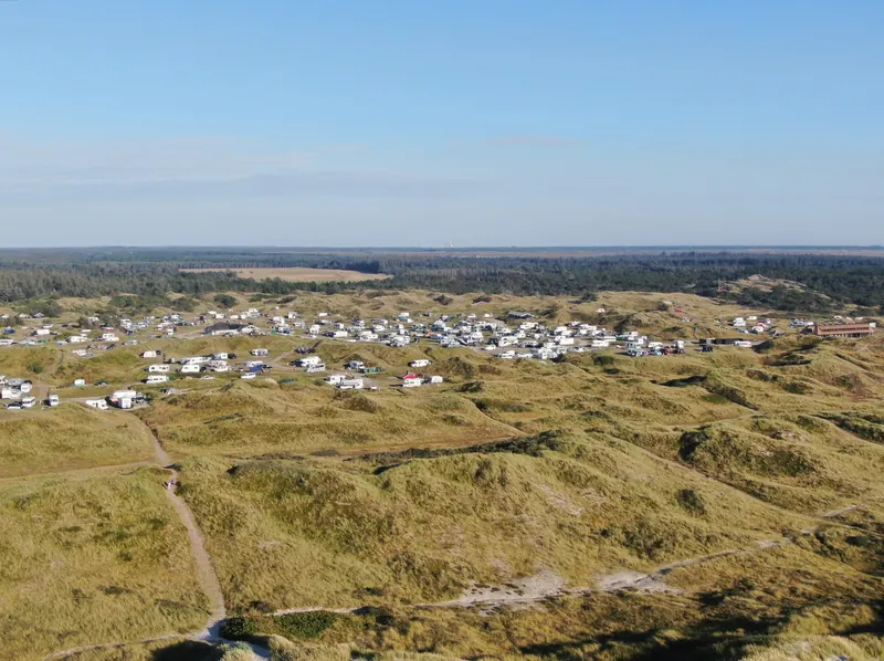 Utsikt over klitlandskapet ved Vejers Strand med en campingplass full av campingvogner i bakgrunnen